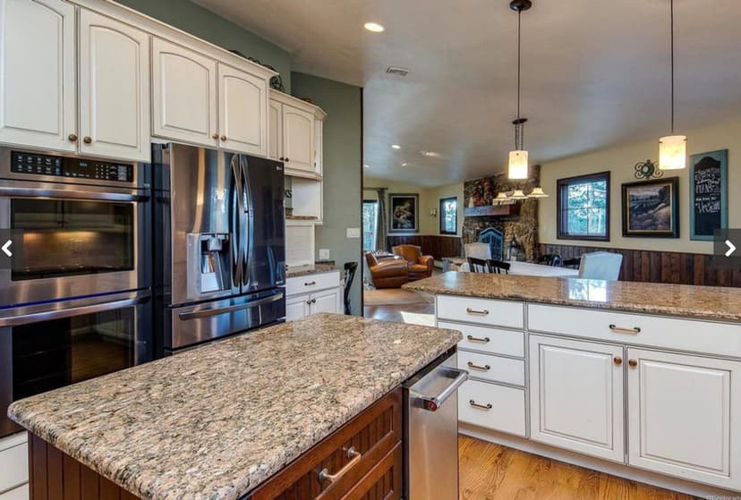 Modern kitchen with granite countertops, stainless steel appliances, and open floor plan.